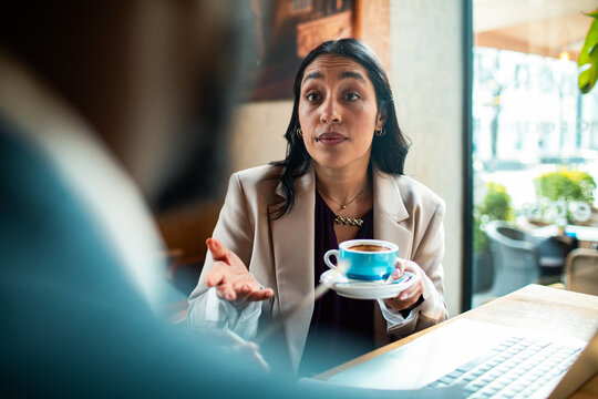 Businesswoman discussing project over coffee at cafe