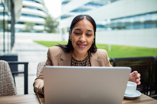 Businesswoman working on laptop at outdoor cafe
