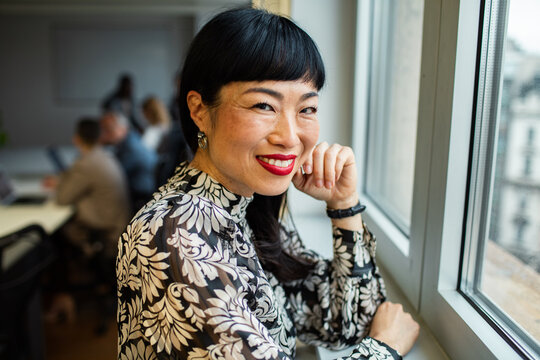 Portrait of smiling businesswoman by office window