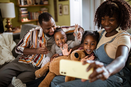 Happy family taking selfie on couch at home