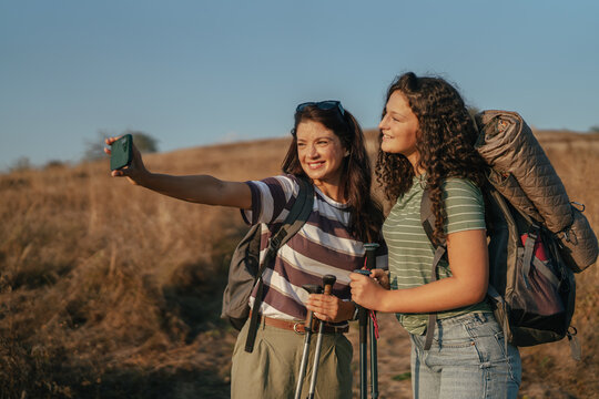 Two women hiking taking selfie on trail