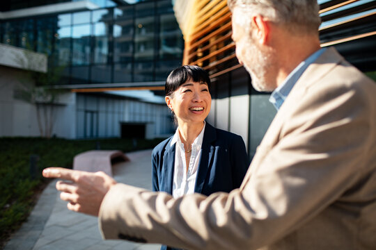 Two business colleagues talking outside modern office