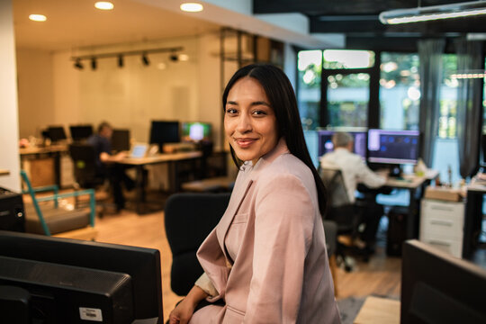 Confident businesswoman smiling in modern creative office
