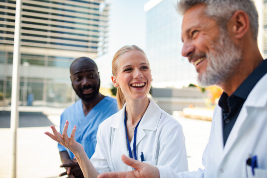 Diverse medical team talking outside hospital