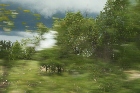 Intentional camera movement motion blur landscape of trees and a stormy sky