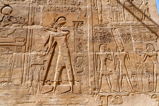 Ancient Egyptian Stone Bas-Relief Carving Featuring Pharaohs and Deities with Intricate Hieroglyphics Displayed on Walls of Historic Temple Site in Luxor Egypt