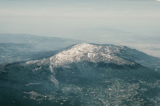 Aerial view of Uludag mountain with snow-capped peaks, forested slopes, and surrounding valleys in Kestel, Bursa, Turkiye.