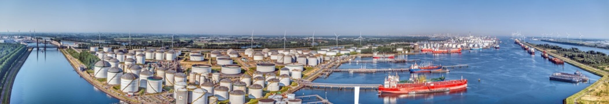 Aerial panorama of Rotterdam port with container ship and wind turbines