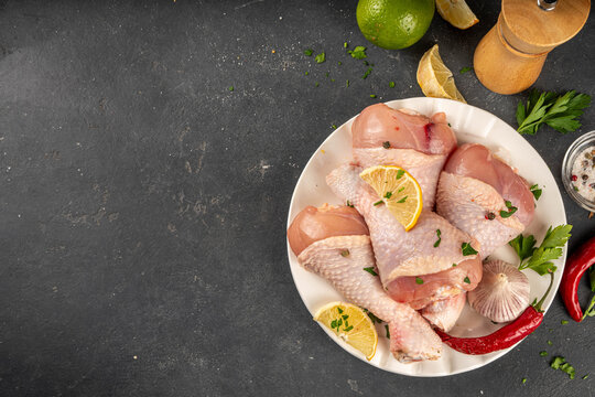 Fresh raw organic chicken legs, drumsticks, with spices and condiments