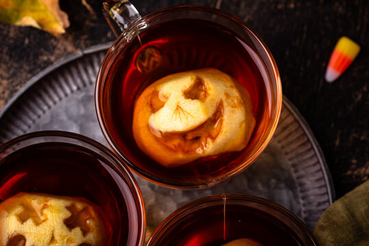 Halloween spicy apple cider with jack-o-lantern faces