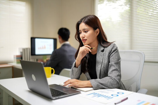 Business professionals analyzing data and working on laptop during office meeting for corporate presentations and marketing materials