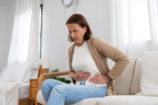 Mature caucasian woman touching her belly suffer from stomach ache