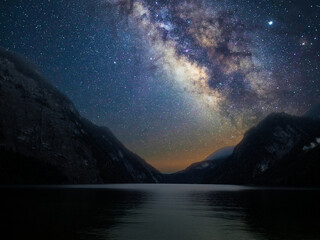 Milky Way galaxy with stars in the night sky with mountain and lake © Denwisit