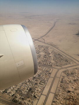 High angle view of desert land and city from airplane