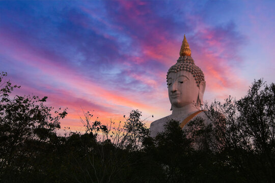 Big Buddha statue head with sunrise sky