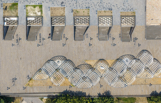 Aerial view of modern architectural structures and geometric patterns in a Skopje plaza, with intricate metal canopies casting shadows on the ground Skopje, Greater Skopje, North Macedonia.