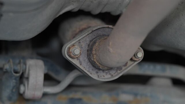 Close up shot of rusty car exhaust pipe flange joint.