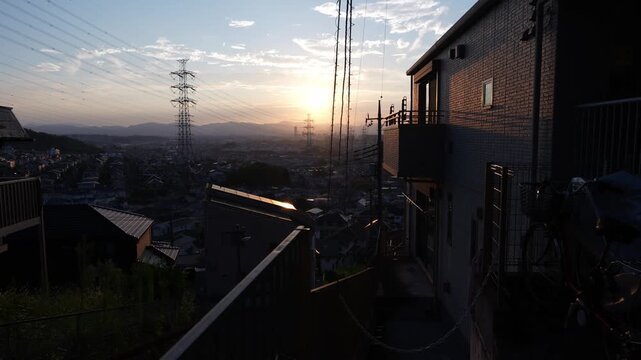 東京都日野市の郊外に広がる住宅街と送電鉄塔の夕景
