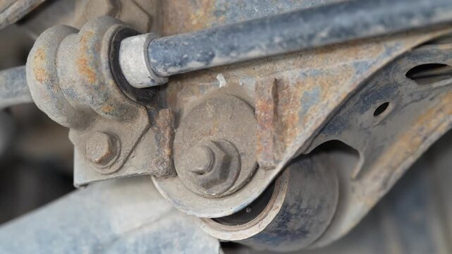 Close up shot of rusty underbody car suspension control arm.