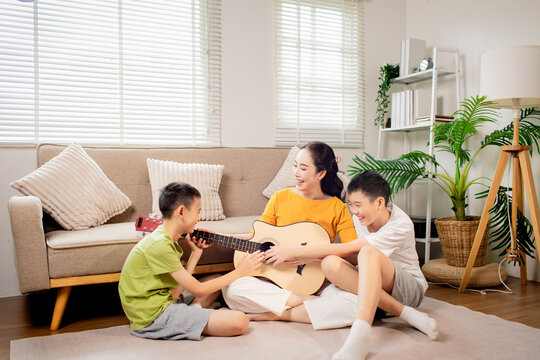 Two Brothers Playing Guitar Together at Home