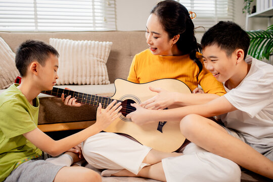 Two Brothers Playing Guitar Together at Home