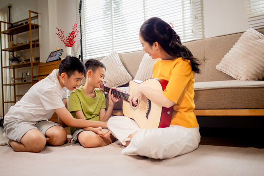 Two Brothers Playing Guitar Together at Home
