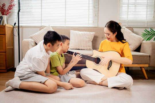 Two Brothers Playing Guitar Together at Home