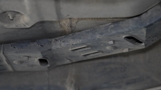 Close up shot of dirty metal car underbody frame reinforcement.