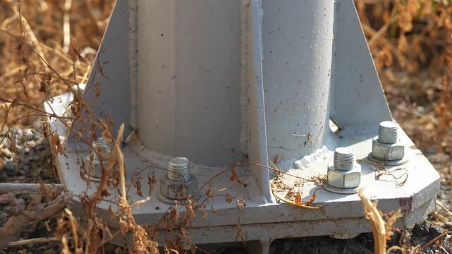 Close up shot of steel lighting pole base flange anchor bolts.
