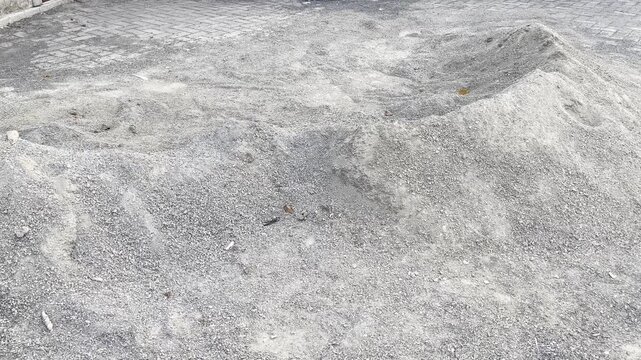 Pile of construction sand on interlocking concrete paving blocks