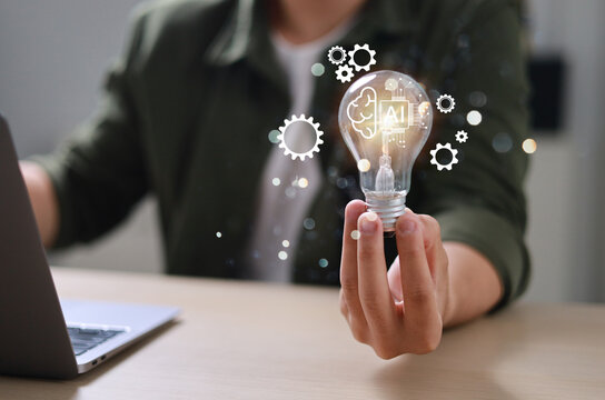The hand of an entrepreneur holding a light bulb: inspiration for sustainable business development and a modern strategic business problem-solving approach.