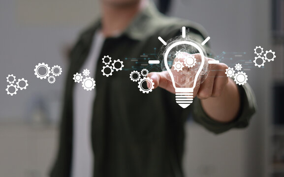 The hand of an entrepreneur holding a light bulb: inspiration for sustainable business development and a modern strategic business problem-solving approach.