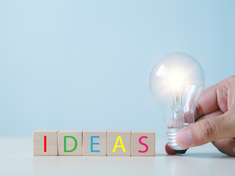 New business ideas and strategic consulting. Mobile wooden block with light bulb icon. Brainstorming creativity and expertise.