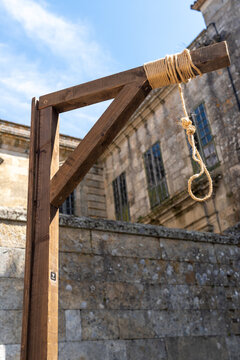 Low Angle View of Wooden Gallows and Noose Against Stone Building