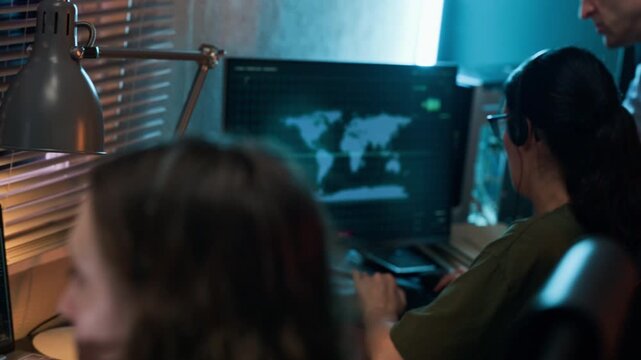 Caucasian military officers analyzing global map on screen, transitioning to close up of young adult female operator speaking on headset. Clip is perfect for national defense and security videos