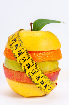 Ein Ma&szlig;band ist um eine Gruppe verschiedener Obstsorten gewickelt als Symbol f&uuml;r Di&auml;t und gegen &Uuml;bergewicht