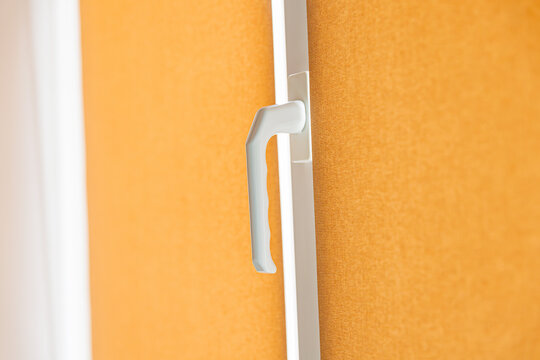Plastic door handle detail close up, modern white pvc frame lock mechanism for home security concept