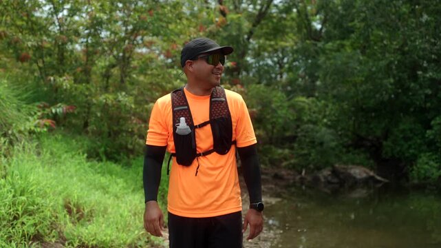 Portrait man trail running through a mountain forest. Extreme outdoor workout represents endurance, personal challenge and determination while pursuing fitness goals and a healthy active lifestyle.
