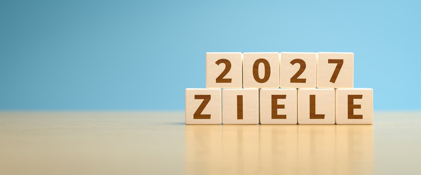 Wooden toy cubes forming the German language text "2027 ZIELE". Concept for planning the actions and goals for 2027.
