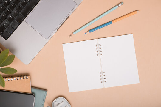 Workspace with open notebook, laptop, and writing tools on a desk