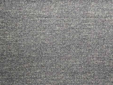 Dark grey denim fabric texture background, close up detail of casual jean material
