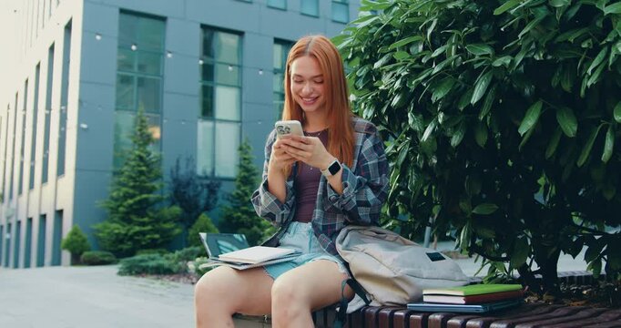 Close-up woman holding phone outdoors female student girl browsing social network sending sms message checking email on smartphone using mobile application chatting