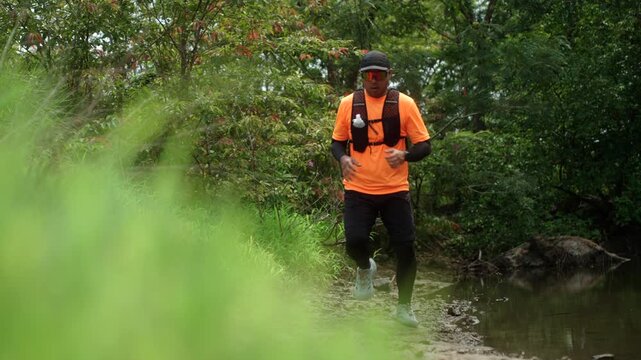 Man trail running through a mountain forest. Extreme outdoor workout represents endurance, personal challenge and determination while pursuing fitness goals and a healthy active lifestyle.
