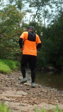 Man trail running through a mountain forest. Extreme outdoor workout represents endurance, personal challenge and determination while pursuing fitness goals and a healthy active lifestyle.
