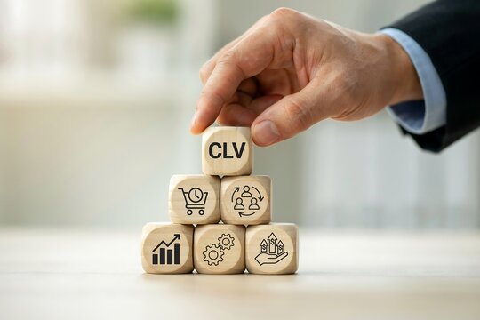 Hand stacking wooden blocks with icons to represent customer lifetime value and business growth