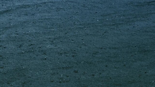 Raindrops splashing on dark water background