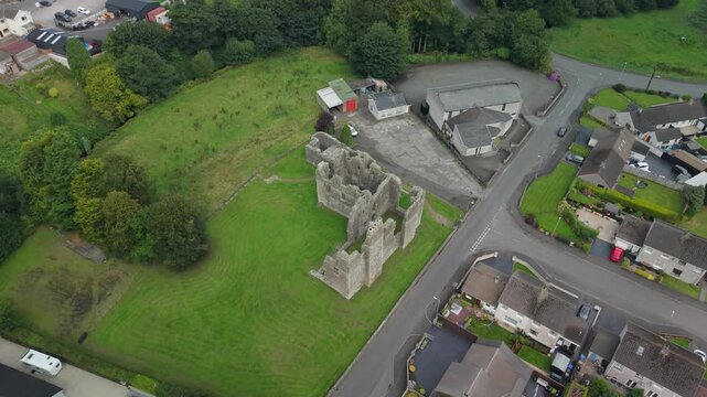 Drone descending over the roofless stone ruins of Castle Caulfield, Castlecaulfield, County Tyrone, Northern Ireland