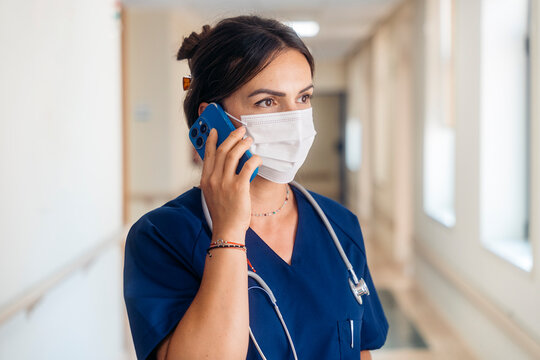 Medical professional talking on phone in hospital hallway
