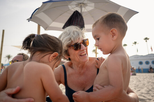 Grandmother bonding with grandchildren during beach vacation