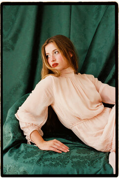 Woman resting on emerald fabric